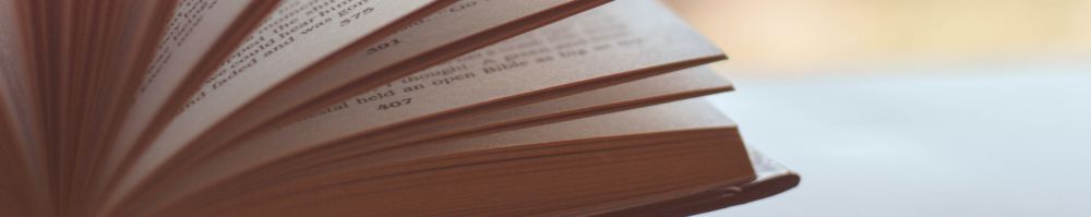 a book open to reveal its pages in a fan against a blurred background.