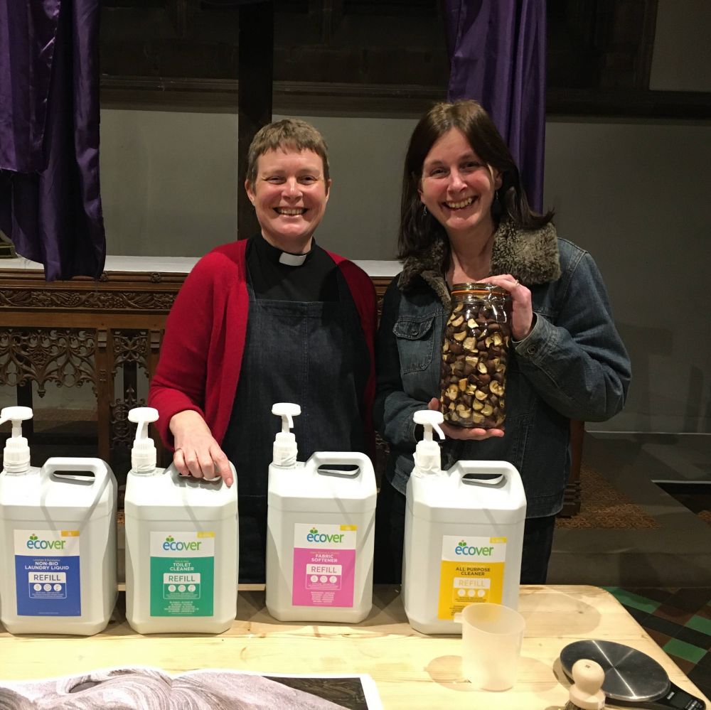 Tubs of renvironmetnally friendly cleaning fluid with two people stood behind smiling